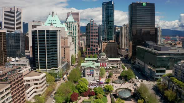 Aerial scene of a people walking to a political rally in a major downtown city. A beautiful urban pa