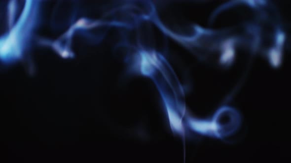 Realistic cloud smoke with a streamlined pattern. Abstract blue smoke on dark background in slow mot