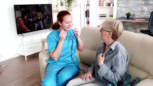 Nurse Woman in Retirement Home Checking on Old Lady