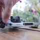 Close Up a Man's Hand Lifts Body of a Broken Drone with Wooden Floor - VideoHive Item for Sale
