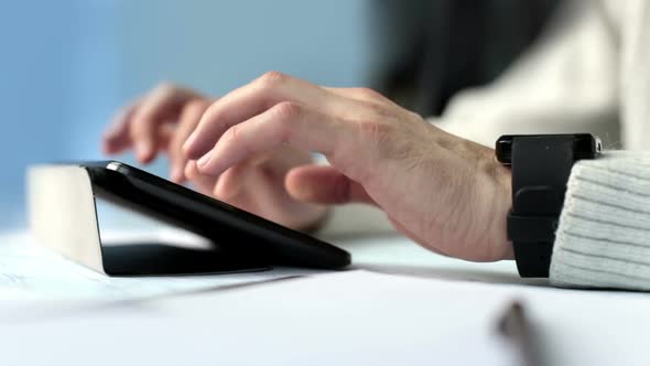 Young Engineer Works with the Drawings on the Tablet