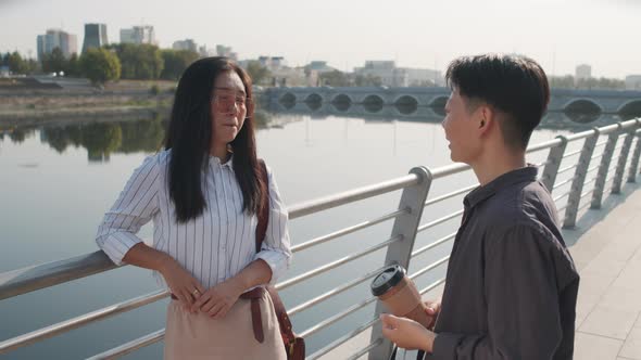 Two Asian Women Chatting at Embankment