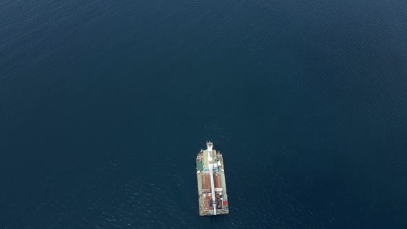 Cargo Ship with a Crane is at Sea Far From the Shore