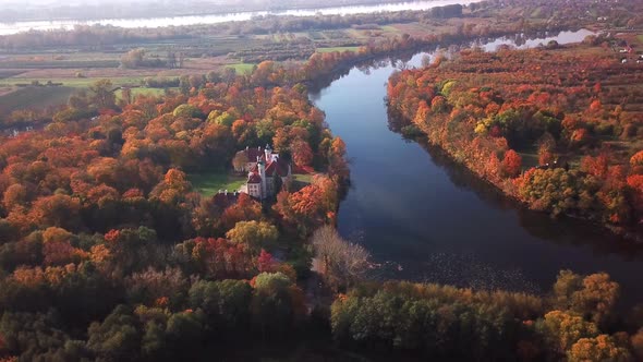 Aerial View: Castle By The River. Flight over beautiful castle; located in landscape park with green