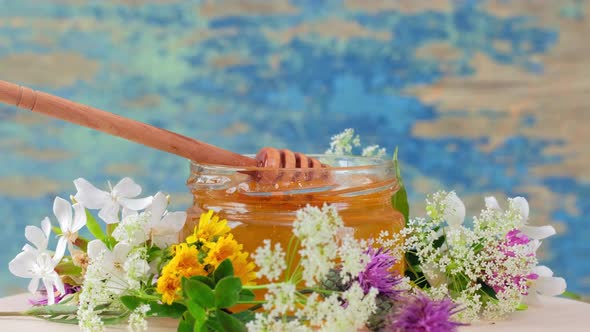 The Glass Jar with Fresh Honey Rotate Slowly on the Rustic Background