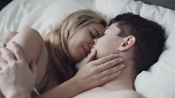 Young Couple in Underwear Passionately Kissing in Morning After Waking Up