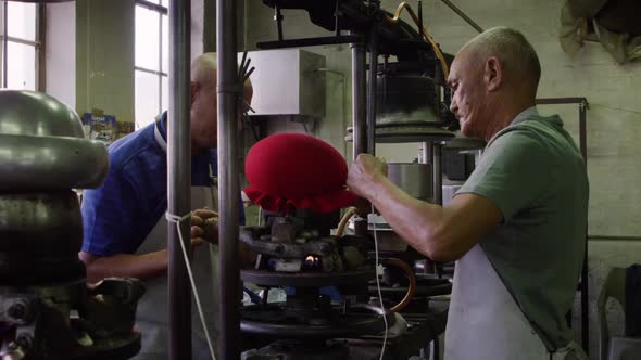 Mixed race men working at a hat factory