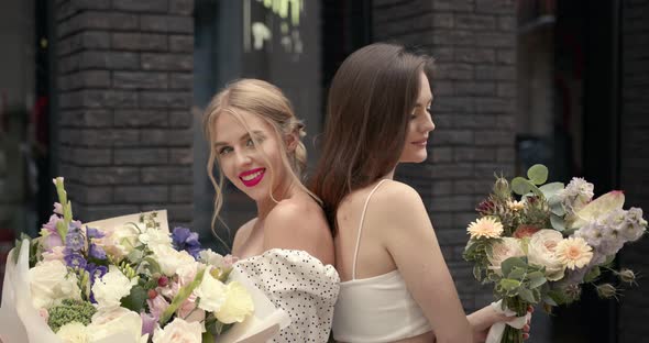 Elegant Women with Bouquets Posing in the City