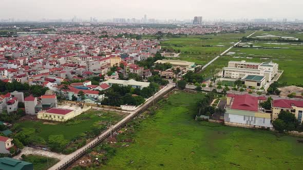 Aerial View Over a Suburban District Near a City with a Highway and Green Field