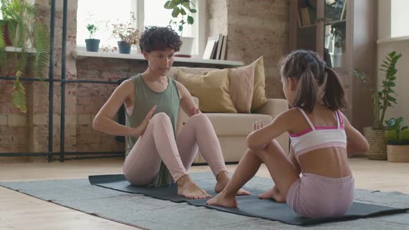 Mother Teaching Yoga Pose to Daughter