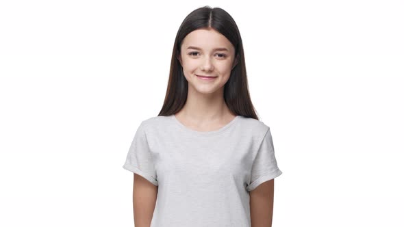 Portrait of Satisfied Teenage Woman in Basic Tshirt Looking at Camera and Smiling Positively While