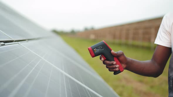 Technician in Helmet Using Thermal Imager on Solar Farm