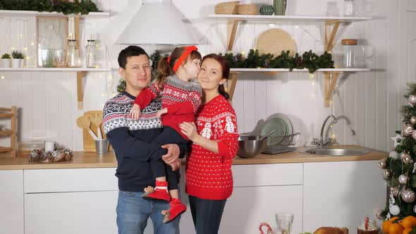 Family Poses at Photoshoot Against Yellow Garland in Kitchen
