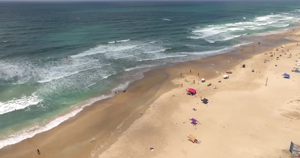 Crowded public beach with colourful umbrellas