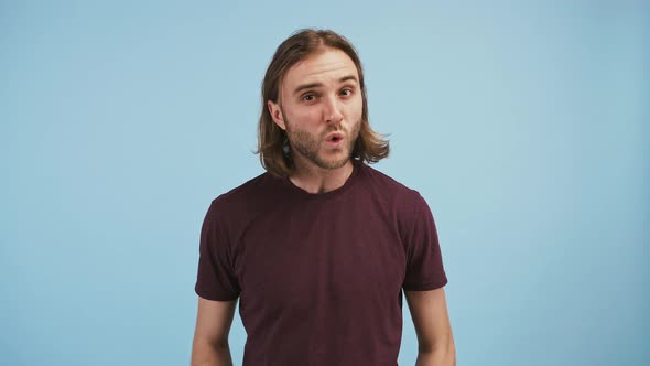 Young Man is Asking What Saying I Do Not Know Spreading His Arms and Shaking Head Posing Against