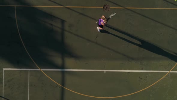 Aerial footage of a female tennis player playing tennis on a tennis court