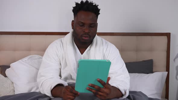 Portrait of Concentrated Serious African American Man Waving in Tablet Greeting Talking