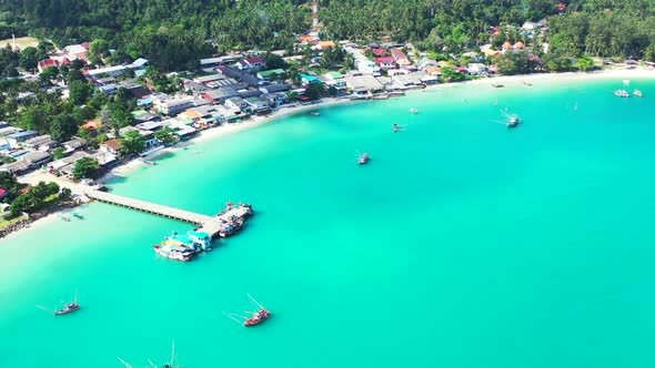 Chalok Lam bay with boats floating around the pier in calm turquoise lagoon. Koh Phangan, Thailand.