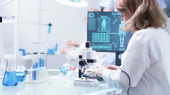 Close Up Footage of Woman Researcher Looking in a Microscope