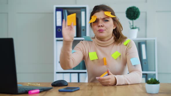 Office girl covered with colored stickers at workplace