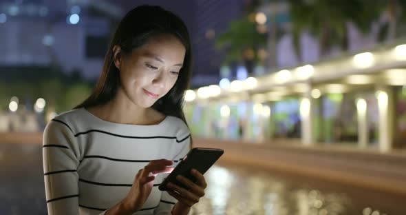 Woman looking at mobile phone at night 