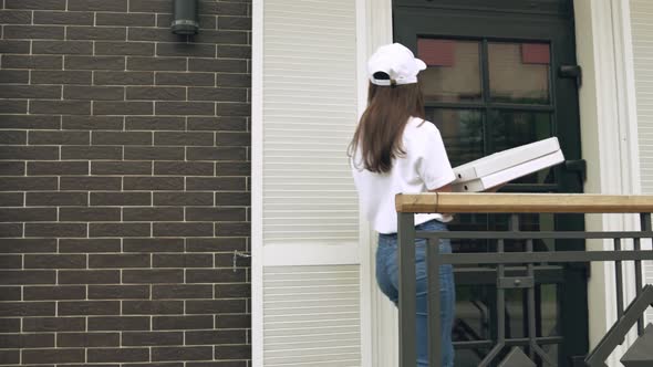 Smiling Deliverywoman Carrying Boxes of Pizza.