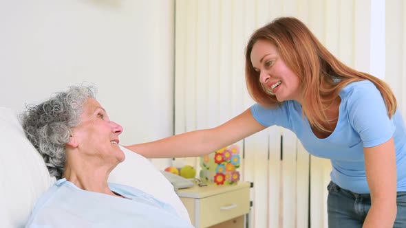 Smiling woman holding the hand of a patient in a room