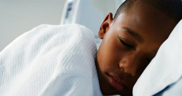 Sick boy sleeping on the bed in the hospital