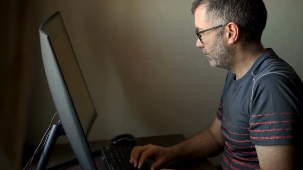 Senior Man is Working in Front of Computer Businessman is Using Large Monitor Sitting at the Table