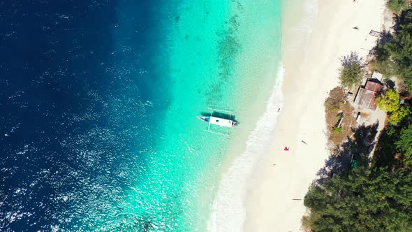 Natural above island view of a white paradise beach and aqua blue ocean background in colourful 4K