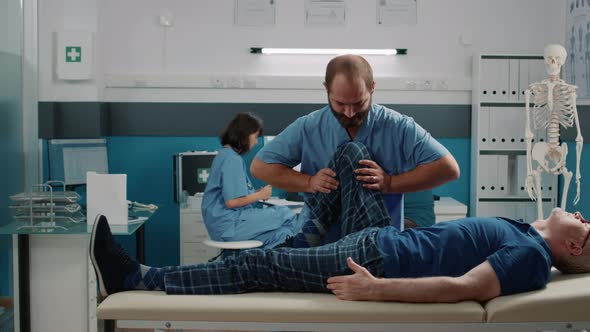 Male Practitioner Doing Legs Raise Procedure to Crack Bones