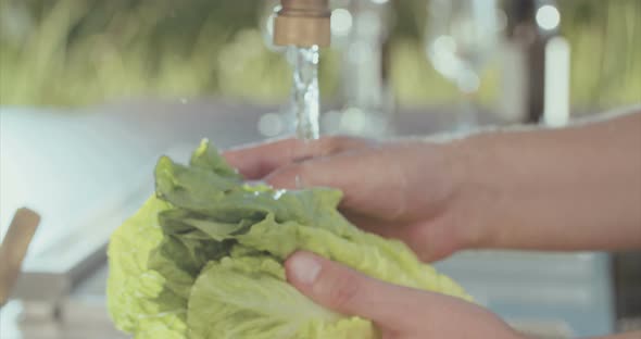 Slow motion of lettuce washed in water in an outdoor kitchen