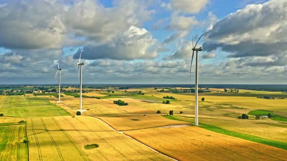 Aerial view of wind turbines on golden field in summer