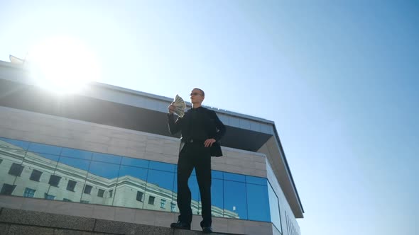 Business Man Manager Worker Wears Suit, Stands Outdoor Near Modern Blue Glass Building, Holds