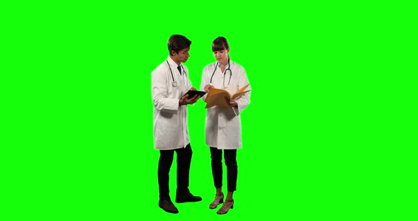 Front view of doctors checking their results on digital tablet with green screen