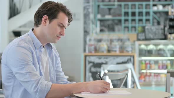 Young Man Having Failure Writing on Paper