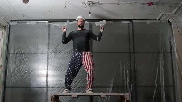 Fat Bearded Adult Man in Protective Helmet and USA Flag Print on Pants Remove Construction Whitewash