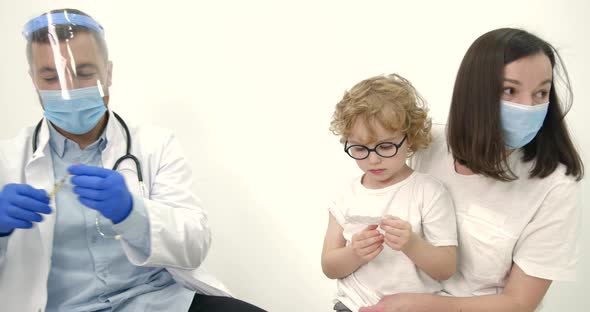 Mother with Kids Vaccinating at Pediatrician Office