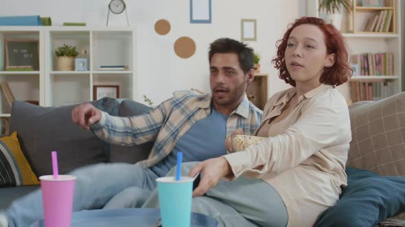 Man Jumping on Couch to Girlfriend