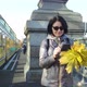A Middleaged Woman a Brunette Caucasian Race with a Bouquet of Yellow Leaves Walks Across the Bridge - VideoHive Item for Sale