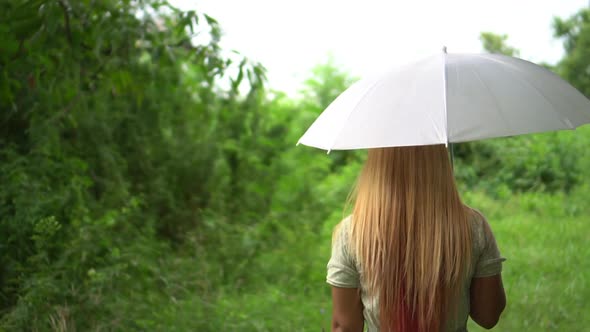 Woman walking hand holding white umbrella under rain