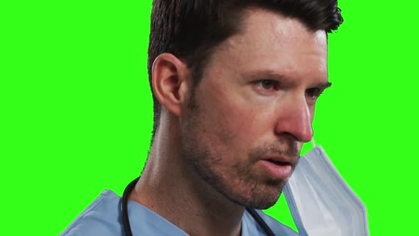 Caucasian male doctor wearing face mask on green screen background