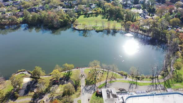 A drone view over Grant Pond in a Long Island, NY suburb. The camera truck right, tilted down over t