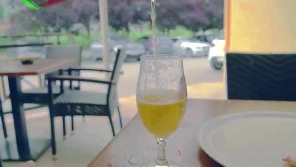 Beer being poured into a wineglass in a restaurant. Fresh bear pouring into glass at a restaurant.