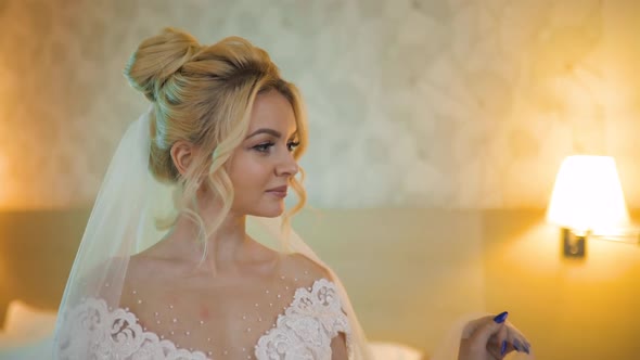Pretty Blonde Bride Wedding Dress Sits Hotel Room Looks Away