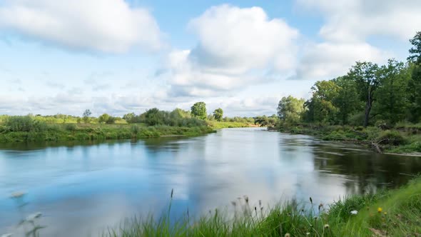 Clouds reflected in the smooth water of a river.