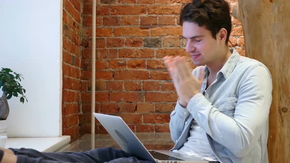 Young Man Upset by Loss while Working on Laptop