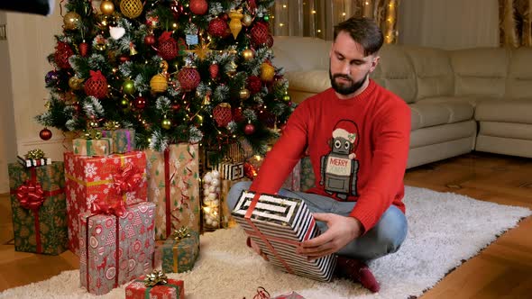 Young Caucasian Man Packing Gifts for Christmas