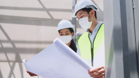 Asian workers man and woman people wear protective mask onsite of architecture due to COVID pandemic