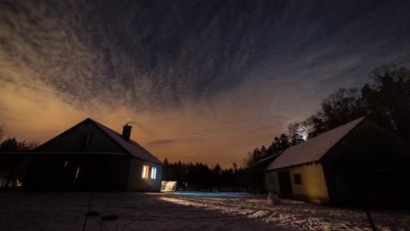 Night Starry and Cloudy Sky Over House and Snowed Backyard